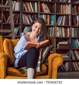 Reading Smiling Young Beautiful Woman. Happy Relaxed Weekend In Home Library. Stylish Room Interior