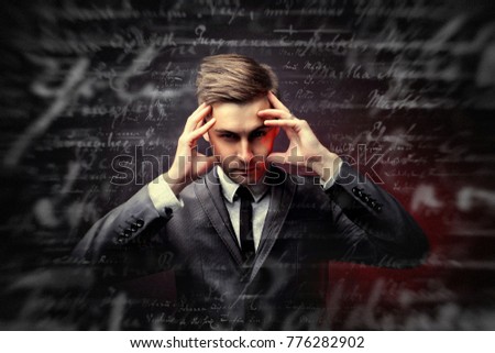 Reading of thoughts. The guy holds his fingers at his temples and looks with a penetrating gaze