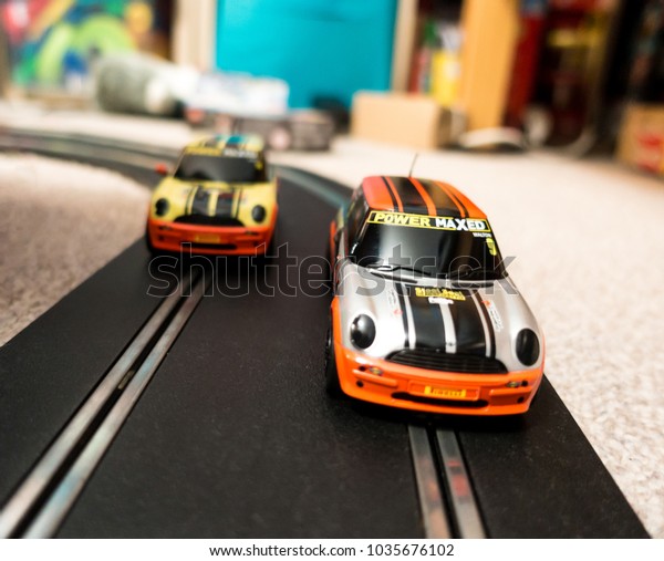 Reading, UK - February\
24, 2018: A close up view of two toy slot cars on a racing track in\
a child\'s bedroom.