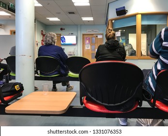 Reading, UK - March 5 2019: People Sit And Wait To Be Seen In The Accident And Emergency Department Waiting Area.