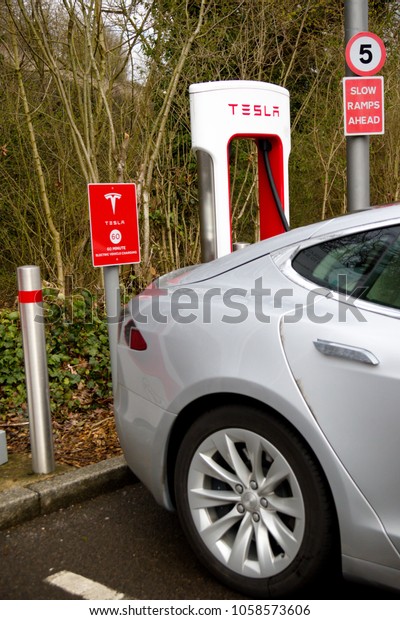 Reading, United Kingdom, 31th March 2018:- A\
Tesla Model S charges at the Tesla Supercharger station at\
Reading’s Green Park. Superchargers allow for rapid charging\
compared to home\
charging.