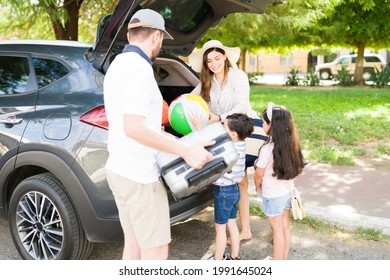 Ready For The Beach. Happy Family Packing The Car With Floaters And Balls While Preparing To Go To The Pool During A Summer Holiday 