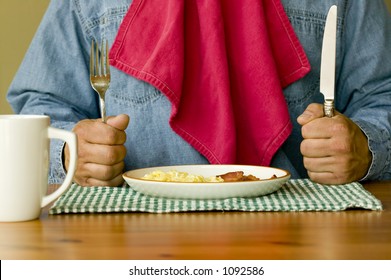 Ready For Breakfast Hungry Man Holding Knife And Fork With Napkin Tucked In Shirt Ready To Eat Bacon And Eggs For Breakfast.