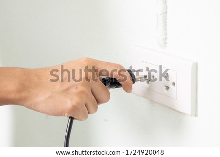 Ready to connect. Plugging electrical, black plug in electric socket on wall.