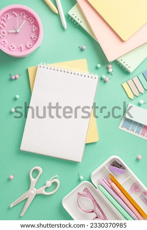 Ready for creativity concept. Top view of vibrant art supplies, sketchbooks, colored pencils, sticky notes, pushpins, scissors, clock, glasses on teal background with space for text or advertisement
