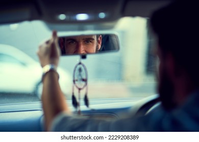 I am ready for the day. Rearview shot of a unrecognizable man driving in his car while looking into the rearview mirror.