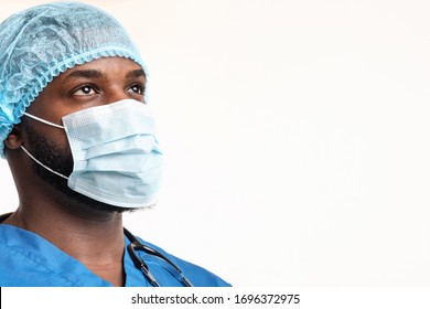 Ready to fight with covid-19. Young black male surgeon in mask and hair net looking at copy space over white background