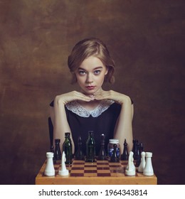 Ready For Game. Young Woman In Art Action Isolated On Brown Background. Retro Style, Comparison Of Eras Concept. Beautiful Female Model Like Legendary Chess Player, Queen Or Duchess, Old-fashioned.