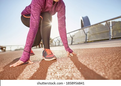 Ready To Go. Cropped Shot Of Active Mature Woman Wearing Sportswear Standing In Start Position, Ready For Running Outdoors On A Sunny Day