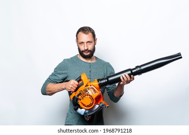 I'm Ready To Go And Start Up My Leaf Blower. Studio Portrait Of Serious Man Holds In Hands Blower Machine. Handsome Caucasian Worker Looking At Camera. People, Lifestyle And Technology Concept