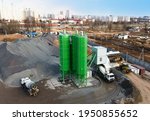 Ready mix concrete batching plant. Producing сoncrete and portland cement mortar for construction and formworks. Pouring concrete through to a ready-mixed truck. Drone view. Out of focus