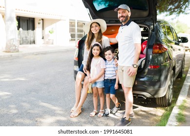 Ready For A Relaxing Weekend On The Beach. Cheerful Hispanic Family Packing Their Car To Go On A Vacation Trip Together 