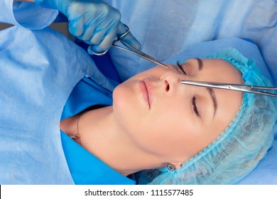 Ready For Rhinoplasty. People, Cosmetology, Plastic Surgery And Beauty Concept - Surgeon Or Beautician Hands Touching Woman Nose With Medical Tools Instruments Preparing For Nose Job In Medical Clinic