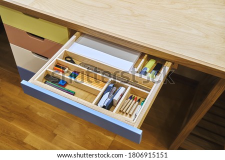 Ready for school. Open desk drawer with various school supplies arranged carefully in order before studies