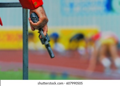 Ready. Set. Go! The Starter's Pistol Is Poised At The Start Of A 200m Sprint Race.