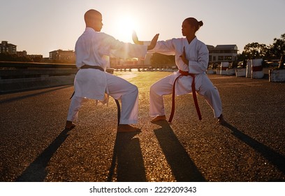 Ready to spar. Two sportspeople facing off and practicing their karate while wearing gi. - Powered by Shutterstock