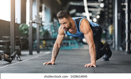 Ready, steady, go. Muscular guy preparing for hard workout in gym, standing on floor in start position, empty space - Powered by Shutterstock