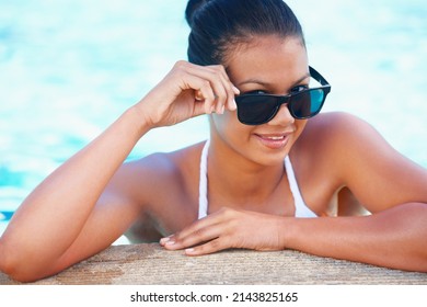 Ready For A Summer Fling. Cropped View Of A Young Woman In A Swimming Pool Smiling While Wearing Shades.