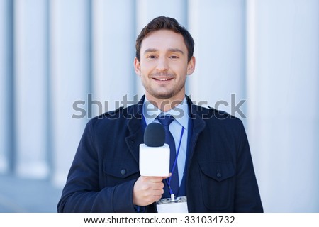 Ready to take down. Young journalist looks confident before taking down another newscast. 