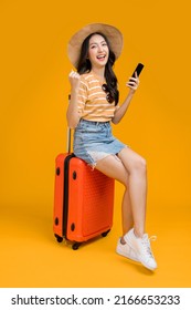 ready to travel ,asian smiling cheerful female woman hand using smartphone check flight schedule pull luggage bag prepare to new abroad journey travel studio shot on yellow background  - Shutterstock ID 2166653233