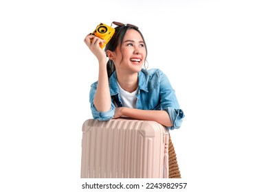 ready to travel ,young teen asian smiling cheerful female woman casual cloth hand hold camera standing with luggage case bag prepare to new abroad journey travel studio shot on white background 