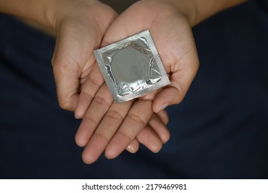 Ready-to-use condoms on female hands Keep condoms safe in bed. prevent infection and contraception on World AIDS Day Leave space for text
