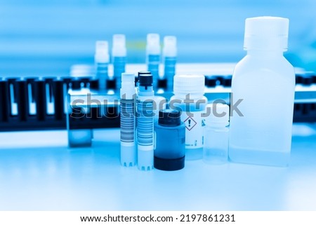 Reagent tubes and bottes for laboratory analysis automate machine.Sample specimen in test tube and chemistry and immunology reagent bottle on white table background for laboratory analysis.