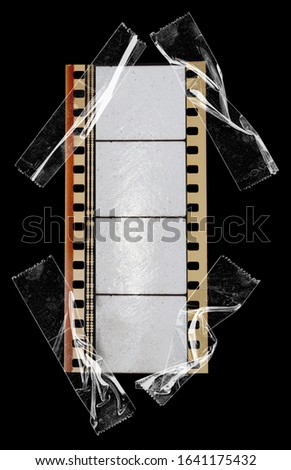 real 35mm cine phono film strip with empty cells or frames isolated on black backgroud with cool texture and optical stereo sound, analog soundfilm or movietone fixed by sticky tape, macro photo.