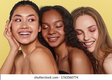 The real beauty exists in every corner of the world and is presented by women of all races. Three beautiful smiling ladies with different skin and hair colour are posing close to each other.