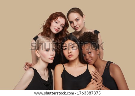 The real beauty exists in every corner of the world and is presented by women of all races. Group portrait of five beautiful ladies in black tops and with different skin and hair colour.
