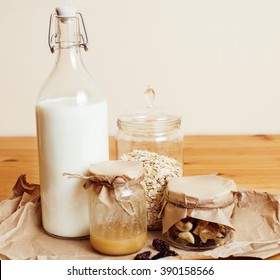 real comfort wooden kitchen with breakfast ingredients close up in glass, honey, oatmeal, milk, muesli