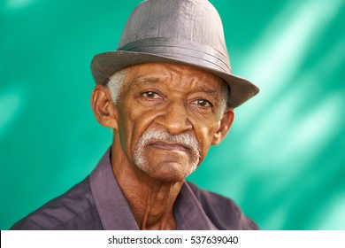 Real Cuban People And Feelings, Portrait Of Sad Senior Hispanic Man Looking At Camera. Worried Old Latino Grandfather With Mustache And Hat From Havana, Cuba