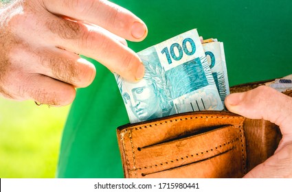 Real Currency. Money, Dinheiro, Brasil, Reais. Man Holding In Hand A Group Of Real Banknotes. Salary, Laborer, Worker.