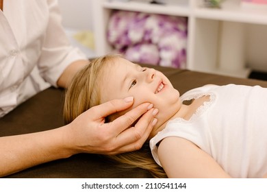 real doctor osteopath hands does physiological and emotional therapy for four year old kid girl. pediatric osteopathy treatment session. alternative medicine. taking care of the child's health