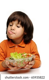 Real Enjoying Fresh Green Salad, Cute Kid With Tongue Out Of His Mouth