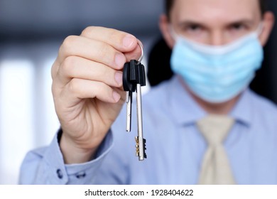 Real Estate Agent, Apartment Keys In Male Hands. Man In Medical Face Mask And Office Clothes, Concept Of Purchase Or Rental Home During Coronavirus Pandemic