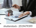 A real estate agent assists a client in buying a home, reviewing contracts, and signing mortgage documents. The process involves financial planning, property investment, and legal paperwork.