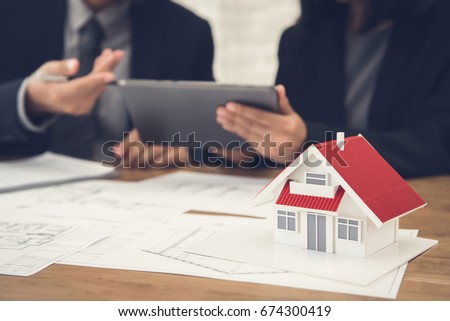 Real estate agent with client or architect team discussing project on tablet computer