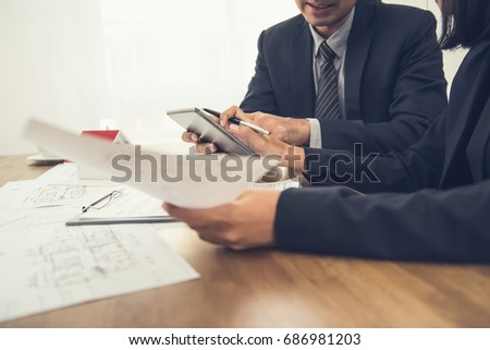 Real estate agent with client or architect team discussing work on tablet computer screen