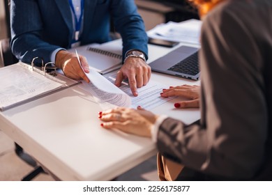 The real estate agent closes the deal with the client and they sign the contract. - Shutterstock ID 2256175877