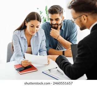 Real estate agent with couple closing a deal and signing a contract - Powered by Shutterstock