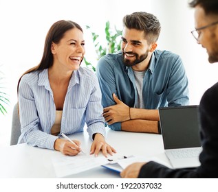 Real estate agent with couple shaking hands closing a deal - Shutterstock ID 1922037032