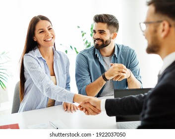 Real Estate Agent With Couple Shaking Hands Closing A Deal