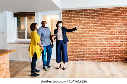 Real Estate Agent And Customer In Face Mask Looking At A New Project