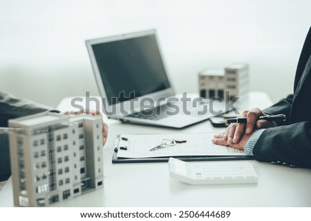 A real estate agent is explaining the layout of a house to a client who is about to buy a new apartment along with insurance interest rates on the title. Close-up photo
