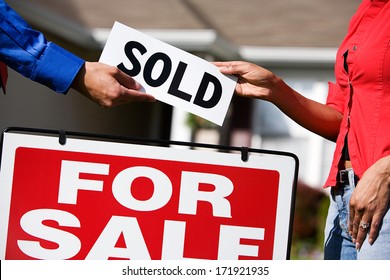 Real Estate: Agent Giving Buyer Sold Sign