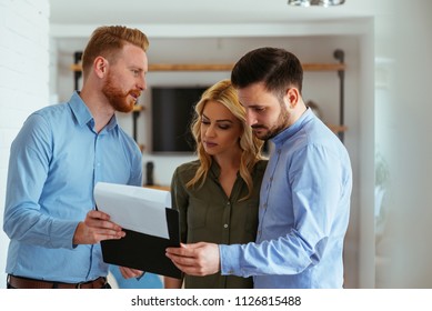 Real estate agent going through the paperwork with the young couple