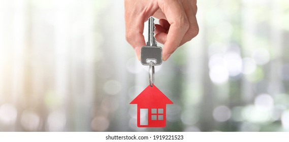 Real estate agent handing over a house keys in hand, and coins