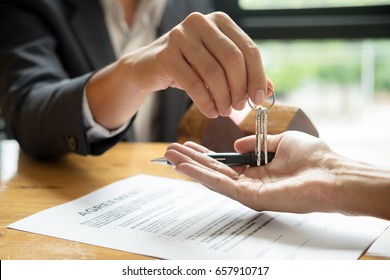Immobilienmaklervermittlungsstelle - Schlüssel für seinen Kunden nach Unterzeichnung des Vertrags im Büro, Konzept für Immobilien, Umsiedlung oder Vermietung von Immobilien 