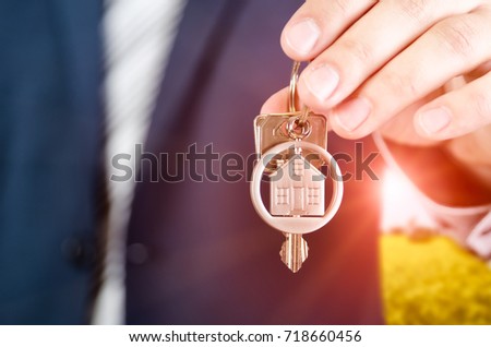 Real estate agent holding key of new apartment close up. realestate key real estate house security home deal concept